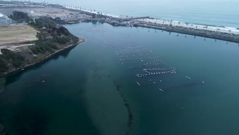 slow-pan-up-Carlsbad-lagoon-and-oyster-farm,-drone-view