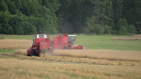 two-pair-of-red-tractor-harvest-machine-working-as-team-in-farm-field-plantation