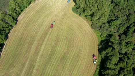 Vista-Panorámica-De-Los-Equipos-Agrícolas-Que-Trabajan-En-Un-Campo-Verde-En-Chmielno,-Polonia---Disparo-De-Drones