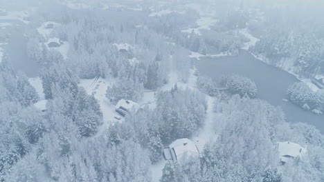Luftaufnahme-Der-Verschneiten-Winterlandschaft-Mit-Haus-Und-Zugefrorenem-See-Im-Kalten-Winter