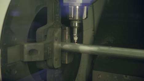 Slow-motion-footage-of-a-laser-cutting-machine-making-holes-and-marks-on-a-steel-pipe