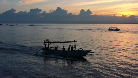 Luftaufnahme-Von-Aufgeregten-Touristen,-Die-Bei-Sonnenaufgang-Auf-Einer-Bootstour-Im-Tropischen-Wasser-Von-Lovina-Bali-Indonesien-Kreuzen