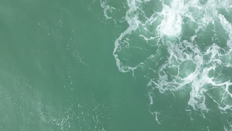 Luftaufnahme-Aus-Der-Vogelperspektive-Des-Türkisfarbenen-Meeres-In-Miraflores,-Peru,-Während-Sich-Die-Wellen-In-Einer-Wunderschönen-Kameraaufnahme-Von-Oben-Treffen
