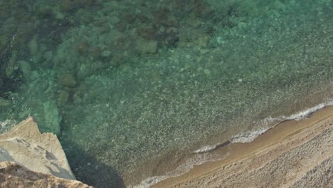 Slow-Motion-Emerald-and-Turquoise-Transparent-Mediterranean-Sea-and-Waves-From-a-Top-Of-A-Cliff-in-Cyprus