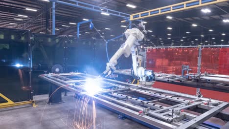 Timelapse-of-a-robotic-welder-moving-around-a-steel-frame-and-putting-in-welds-with-fire-and-sparks