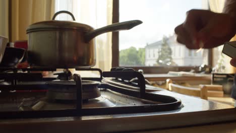 Lighting-gas-stove-and-placing-coffee-pot-on-burner,-Close-Up,-Slow-Motion