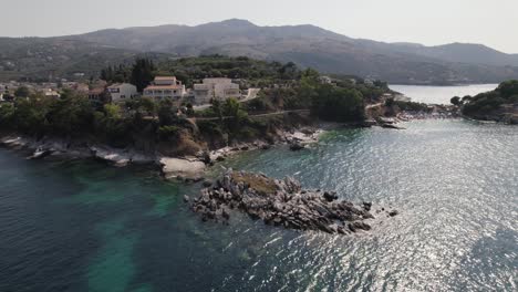 Aerial-flyover-of-hidden-beaches-and-reefs-on-the-island-Corfu,-quiet-tourist-place-Kassiopi