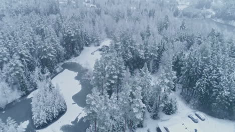 Filmische-Luftaufnahme-Einer-Wunderschönen-Winterlandschaft-In-Den-Bergen-Mit-Schneebedeckten-Bäumen-Und-Häusern