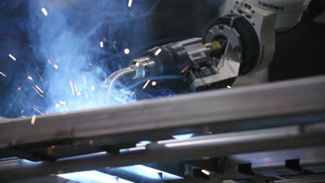 Slow-motion-footage-from-the-ground-of-a-robotic-welder-putting-in-a-weld-on-a-steel-frame
