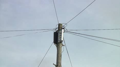 Close-up-to-wide-angle-of-a-wooden-telegraph-pole-in-an-English-town
