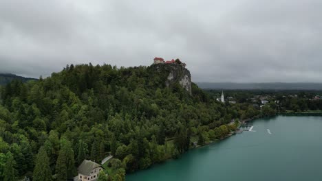 Blick-Auf-Die-Burg-Von-Bled-Mit-Stürmischem-Himmel-Im-Hintergrund-Slowenien-Drohnenantenne-4k