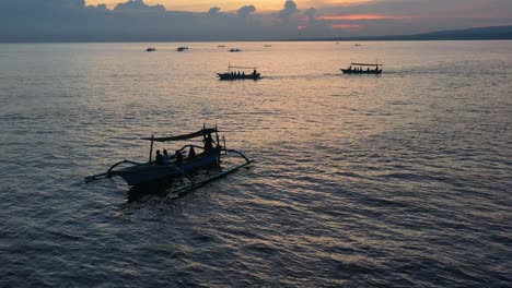 aerial-of-tourists-silhouette-on-jukung-boat-during-sunrise-tour-in-Lovina-Bali-Indonesia
