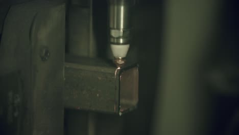 Close-up-slow-motion-footage-of-a-laser-cutter-machine-cutting-through-a-steel-box-pipe