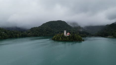 Lake-Bled-Slovenia-push-in-drone-aerial-view-cloudy-background