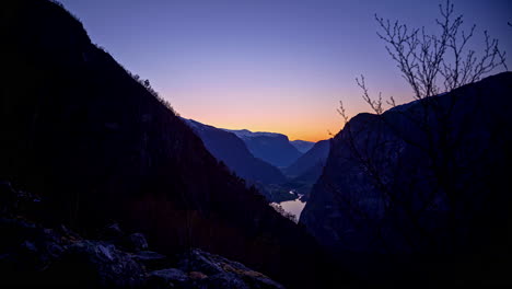 Timelapse-shot-of-mountain-slope-in-Norwegian-Fjord-in-Flam,-Norway-getting-dark-at-dusk