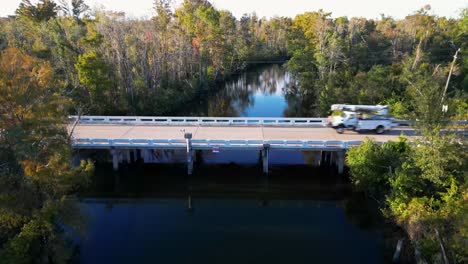 Slow-rise-over-water-with-utility-truck-driving-across-bridge-in-Florida-panhandle