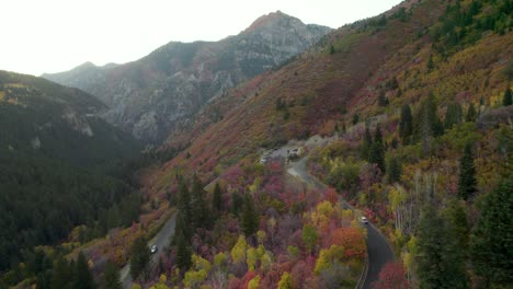 Cars-drive-along-mountain-pass-with-stunning-fall-foliage---American-fork-canyon,-Utah