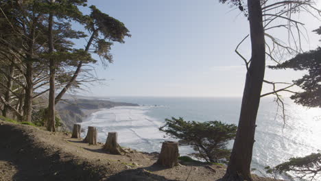 Stationary-shot-of-cliffside-hanging-over-the-pacific-ocean-with-waves-crashing-in-the-background-located-in-Big-Sur-California