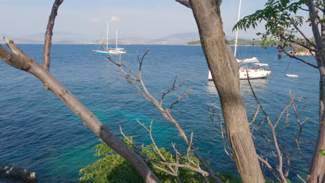 Anchored-sailboats-along-the-coast-of-the-island-Corfu,-fishing-village-Kassiopi,-Greece