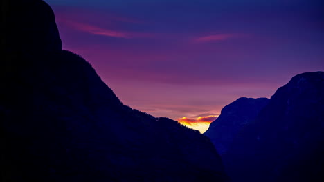 Time-lapse-shot-of-purple-sunset-with-flying-clouds-behind-mountains-in-Norway