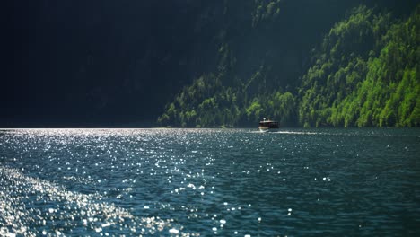 Long-distance-shot-of-a-boat-sailing-on-the-waters-of-Lake-Koenigssee-in-Germany