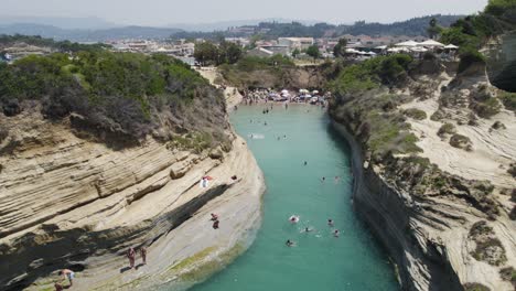 Aerial-establishing-shot-of-Canal-D'Amour-with-people-jumping-off-of-the-cliffs