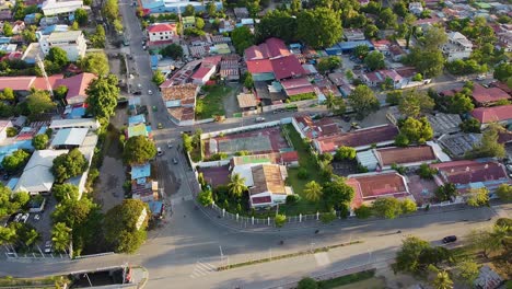 Aerial-drone-birdseye-panoramic-view-of-free-flowing-cars,-scooters,-and-traffic-traveling-along-main-road-in-capital-city-of-Dili,-Timor-Leste-in-Southeast-Asia