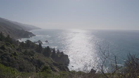 Pacific-Ocean-panning-to-hill-side-Big-Sur-California-on-a-sunny-summer-day