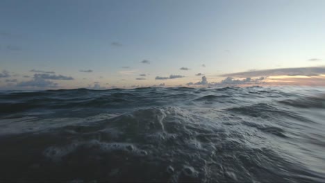 Floating-on-a-calm-beach-at-sunset-in-the-summer---First-person-view-gopro-camera