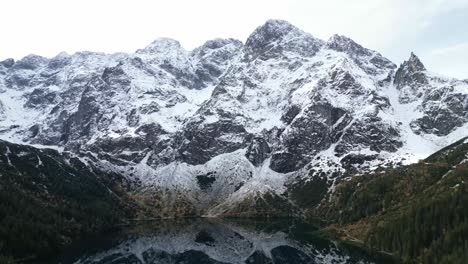 Luftaufnahmen-Von-Schneebedeckten-Gipfeln,-Die-Sich-Im-Morskie-oko-see-In-Zakopane,-Polen,-Widerspiegeln