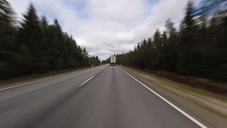 Fast-hyperlapse-POV:-Following-semi-truck-on-country-highway,-cloud