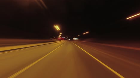 Fast-night-hyperlapse:-Driving-POV-on-dark-highway,-stopping-in-city