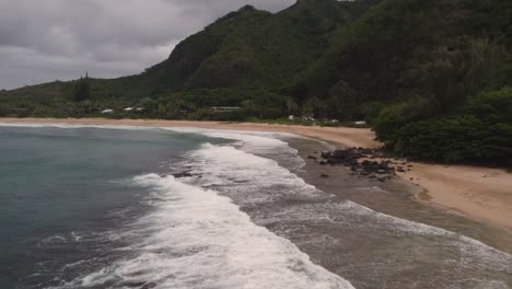 Dramatic-aerial-footage-of-famous-Haena-park,-and-Kalalau-trail-by-NaPali-coast-on-a-cloudy-day