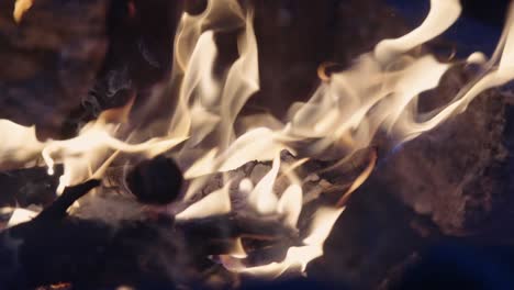 Close-up-of-fire-burning-wood-in-a-sizzling-hot-orange-campfire-at-night,-Slow-Motion,-4k