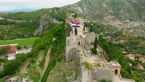 Rotating-low-aerial-view-of-the-side-of-the-fortress-of-Klis-in-Split,-Croatia