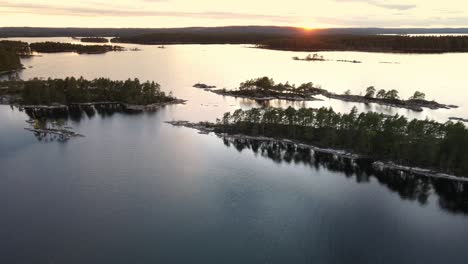 Aerial-view-of-Swedish-nature-landscape-during-orange-sunset-with-a-clear-sky
