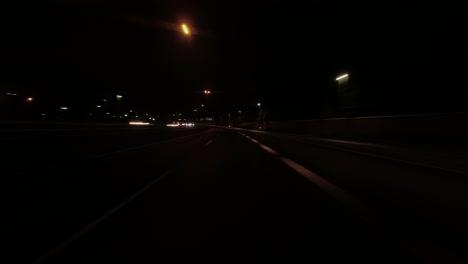 Hyperlapse-POV:-Driving-on-city-freeway-at-night,-stop-at-red-light