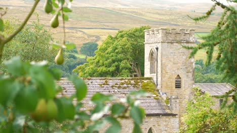CLose-up-shot-of-English-church-nestled-between-pear-tree-in-Yorkshire-Dales