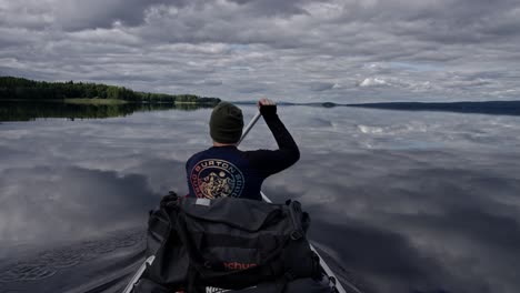 Tourist-Kayaking-on-a-peaceful-mesmerizing-mirror-lake-at-Glafsfjorden,-Sweden