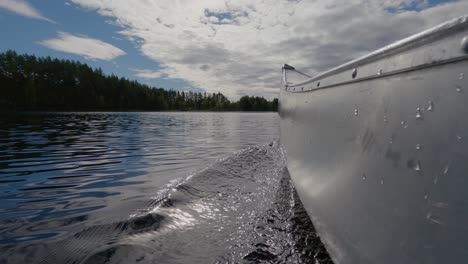 Cu-Blick-Auf-Das-Kanu,-Das-Im-Wasser-Auf-Dem-Schwedischen-See-Unterwegs-Ist-Kajakboot-Auf-Einem-Großen-See-Mit-Blauem-Bewölktem-Himmel