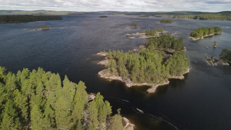 Aerial-shot-of-canoe-paddling-on-water-Swedish-islands,-landscape-with-forest-and-big-lakes,-4k