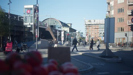 Nørrebro-Station-and-metro-in-Copenhagen,-Denmark,-with-tomatoes-in-the-foreground-from-a-local-shop