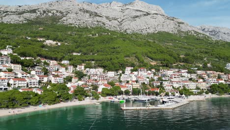 Brela-Croatia-town-and-harbour-waterfront-drone-push-in-shot