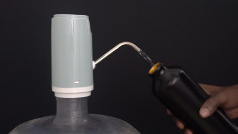 Wasserspenderpumpe-Weitsicht-Schwarzer-Hintergrund-Mit-Handfüllendem-Wasser