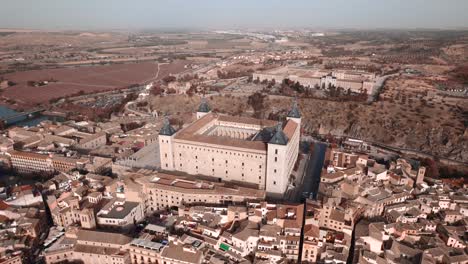A-drone-shot-of-the-Alcazar-of-Toledo-Spain,-surrounded-by-the-fortified-European-Medieval-city