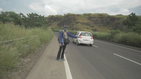 A-hitch-hiking-solo-backpacking-traveller-struggling-to-get-any-lifts-due-to-the-post-pandemic-fear-of-sharing-rides-with-strangers-in-4k-slow-motion