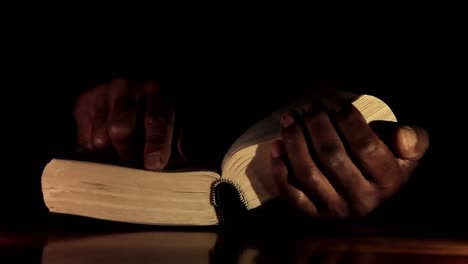 praying-to-god-with-hands-together-with-bible-and-cross-Caribbean-man-praying-with-black-background-stock-video