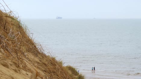 Formby-beach,-Merseyside-coastline-beach-a-ship-sails-on-the-horizon