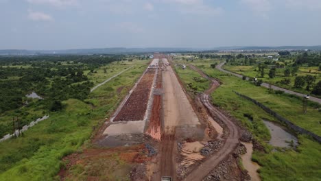 Aerial-view-of-the-Samruddhi-Mahamarg-or-Nagpur-to-Mumbai-Super-Communication-Expressway-under-construction,-the-six-lane-highway-passes-through-many-mountains-and-agricultural-lands