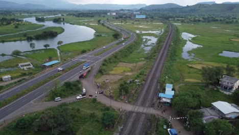 Aerial-view-of-Indian-Railway-Track-and-Indian-Highway-running-parallel-in-one-shot-with-Cargo-Freight-Train-and-Locomotive-Passing